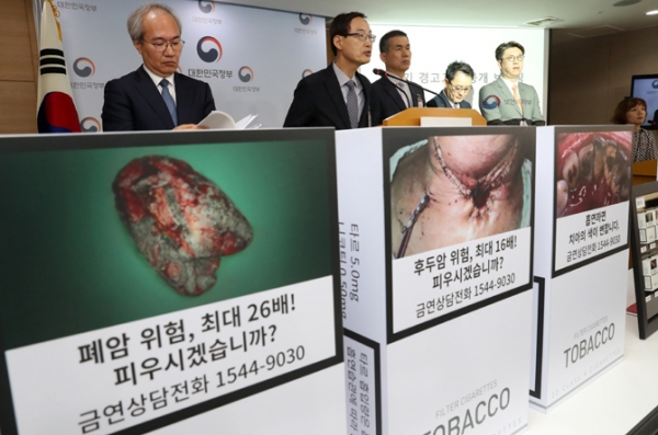 지난해  5월 14일 오전 서울 종로구 정부서울청사 브리핑실에서 권준욱(왼쪽) 보건복지부 건강정책국 국장과 문창진(왼쪽 두번째) 경고그림위원회 위원장을 비롯한 위원들이 담배경고그림 교체 브리핑을 하고 있다.(뉴시스)