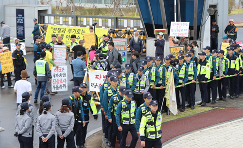 강정마을 해군기지 반대주민회 관계자들이 2019년 10월 18일 오전 제주 서귀포시 제주해군기지 정문 앞에서 유엔군사령부유엔사의 기지 방문 경위 해명을 촉구하는 기자회견을 진행 중인 가운데 경찰과 대치하고 있다  