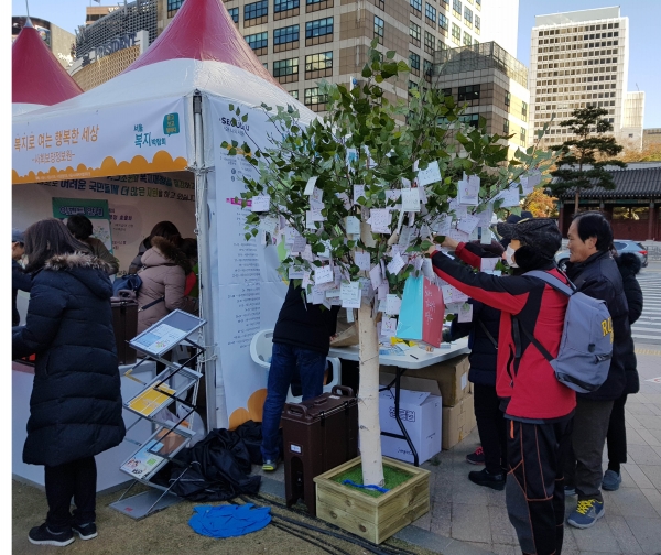 열린 혁신나무 - 함께 만드는 따듯한 복지실현을 위한 아이디어를 시민들이 적어서 나무에 메달고 있다.