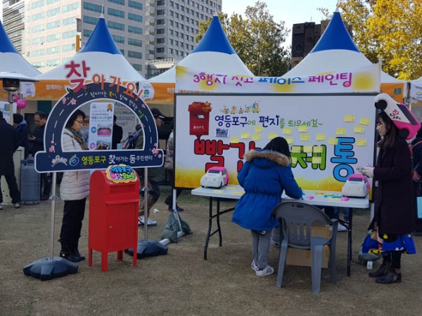 시민들이 영등포구에 하고 싶은 말을 빨간 우체통에 넣 고 있다.