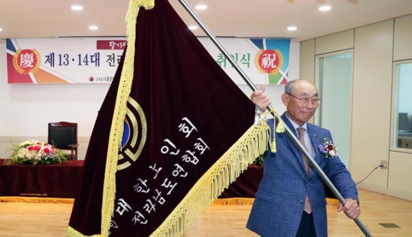 3일 오전 전라남도 무안군 삼향읍 전라남도노인회관에서 열린 (사)대한노인회 제13대, 제14대 전남연합회장 이ㆍ취임식에서 제14대 배기술 회장이 노인회기를 힘차게 흔들고 있다.